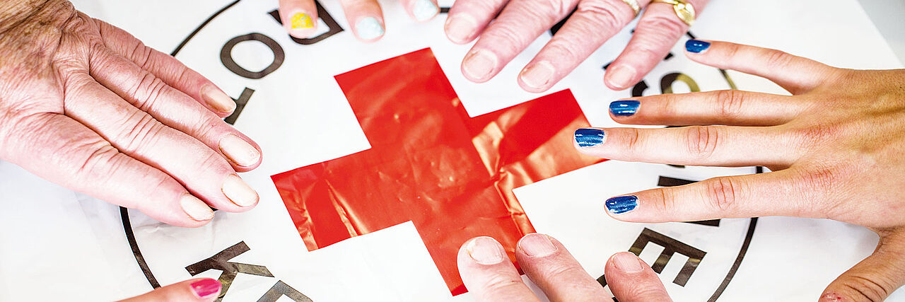 Hände über dem DRK-Logo